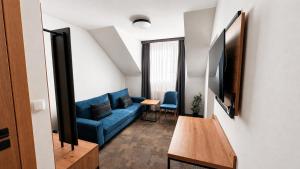 a living room with a blue couch and a table at Hotel Ukiel Wellness & SPA in Olsztyn