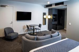 a living room with a couch and chairs and a table at Mantra Tonsley Adelaide in Adelaide