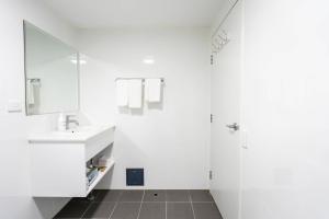 a white bathroom with a sink and a mirror at Comfort Resort Leura Gardens in Leura