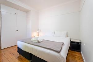 a white bedroom with a large white bed with a lamp at Comfort Resort Leura Gardens in Leura +181 photos