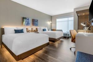 a hotel room with two beds and a desk at Cambria Hotel Mount Pleasant - Charleston in Charleston