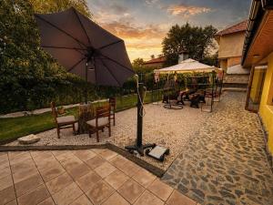 a patio with an umbrella and a table and chairs at Hobbit House in Tsarichino