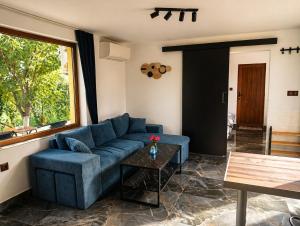a living room with a blue couch and a table at Hobbit House in Tsarichino