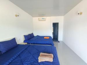 a bedroom with two beds with blue sheets at Vital Point Kampot in Kampot