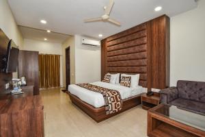 a hotel room with a bed and a couch at Pineberry Hotels - Near Golden Temple in Amritsar