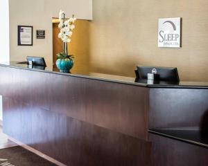 a reception desk in a hotel lobby with a vase of flowers at Sleep Inn & Suites Monticello in Charlottesville +36 photos