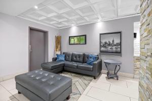 a living room with a leather couch and blue pillows at Quality Inn Albany in Albany