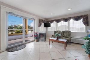 a living room with a tv and a chair and a table at Econo Lodge Thomaston in Thomaston