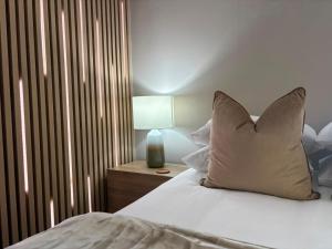 a bedroom with a bed with a pillow and a lamp at Mount Glow Self-Catering in Swellendam