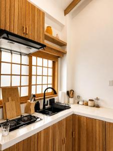 a kitchen with wooden cabinets and a stove top oven at Haku - Japandi Village in General Luna