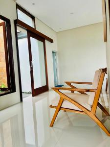 a wooden chair in a room with a window at Omi Homestay in Praya