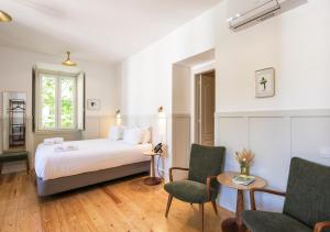 a hotel room with a bed and two chairs at Passeio Sintra Collection in Sintra +87 photos