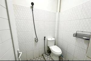 a small bathroom with a toilet and a shower at Hotel O Teratays Homestay in Banda Aceh