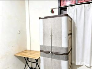 a metal cabinet with a table next to a curtain at Hotel O Teratays Homestay in Banda Aceh