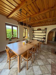a dining room with a wooden table and chairs at Šumavský dům in Drslavice