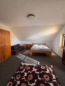 a bedroom with a bed and a couch in a room at Šumavský dům in Drslavice