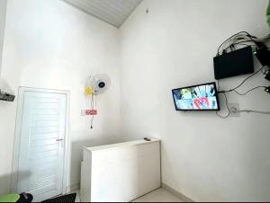 a white room with a tv and a toilet at Hotel O Teratays Homestay in Banda Aceh +20 photos