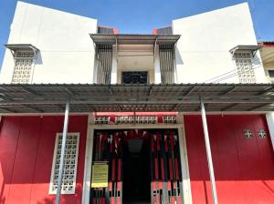 a red and white building with a red door at Hotel O Teratays Homestay in Banda Aceh