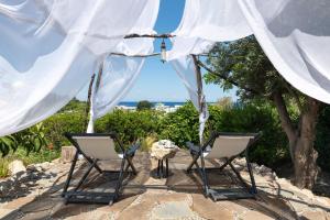two chairs and a table under a tent at Ktima Natura in Archangelos