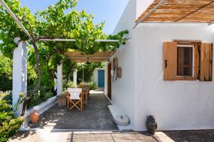 a patio of a white house with a table at Ktima Natura in Archangelos
