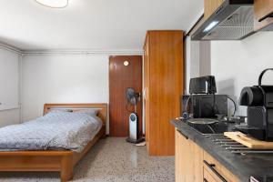 a small bedroom with a bed and a kitchen at les Iris in Pont-Saint-Esprit