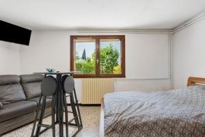 a bedroom with a bed and a couch and a window at les Iris in Pont-Saint-Esprit