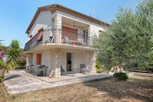 a house with a balcony and a table and chairs at les Iris in Pont-Saint-Esprit