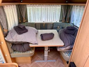 a small room with two beds and a table at Campinplatz Margarethenruh in Nordstrand