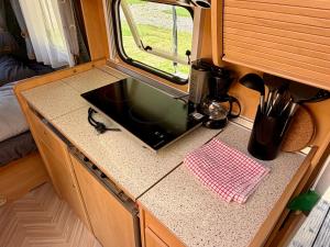 a kitchen counter with a microwave on top of it at Campinplatz Margarethenruh in Nordstrand
