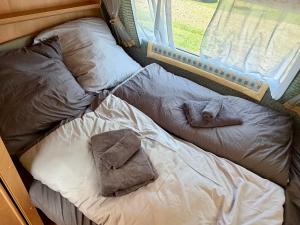 a bed with two pillows and towels on it at Campinplatz Margarethenruh in Nordstrand