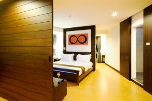 a bedroom with a bed with two olympics on the wall at Kasemsarn Hotel Chanthaburi in Chanthaburi