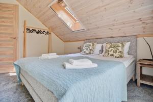 a bedroom with a bed with two towels on it at Tago Forest - Dune Apartments in Jūrmalciems