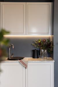 a kitchen counter with white cabinets and a sink at Wahroonga on Bourke in Launceston