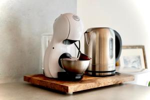 a coffee maker is sitting on a wooden stand at Tago Forest - Dune Apartments in Jūrmalciems