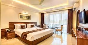 a hotel room with a bed and a desk and a television at Hotel Dreamland Mandarmani in Mandarmoni