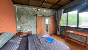 a bedroom with a bed and a brick wall at Love Loft Homestay in Ban Pilok Khi
