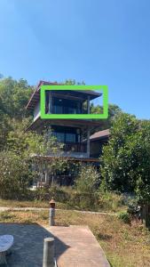 a building with a green sign on the side of it at Love Loft Homestay in Ban Pilok Khi