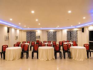 a conference room with white tables and red chairs at Hotel Dreamland Mandarmani in Mandarmoni