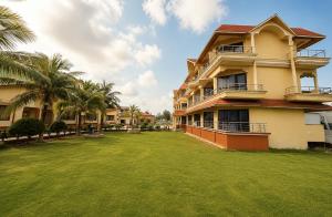 a large yard in front of a building with palm trees at Hotel Dreamland Mandarmani in Mandarmoni
