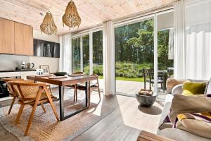 a kitchen and living room with a table and chairs at Tago Forest - Dune Apartments in Jūrmalciems