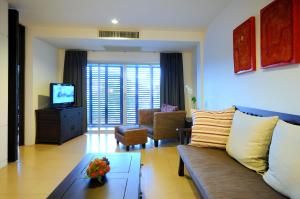 a living room with a couch and a tv at Kasemsarn Hotel Chanthaburi in Chanthaburi