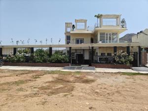 a large house in the middle of a dirt field at The Heritage villa in Udaipur