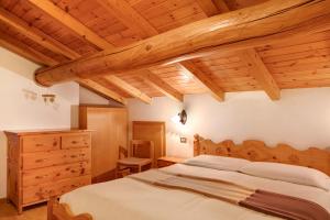 a bedroom with a bed and a wooden ceiling at Appartamenti - Formula Roulette in Livigno