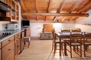 a kitchen with a table and chairs and a kitchen with wooden ceilings at Appartamenti - Formula Roulette in Livigno