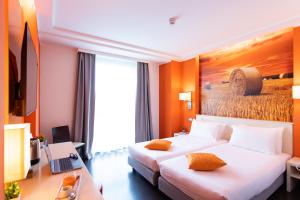 a hotel room with a bed and a desk with a laptop at AN Hotel Milano Melegnano in Carpiano +59 photos