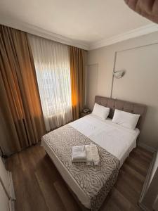 a bedroom with a bed with two towels on it at Kenedi Otel in Altındağ