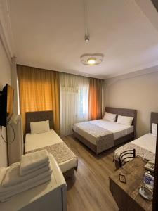 a hotel room with two beds and a tv at Kenedi Otel in Altındağ