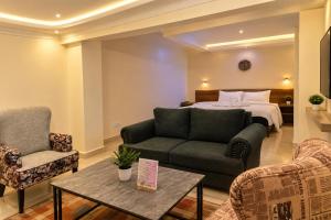 a hotel room with a bed and a couch and a table at COMFORT E SUITES in Nairobi +79 photos