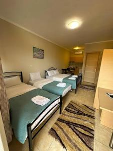 a hotel room with two beds and a kitchen at Anestis Studios in Lidia +53 photos