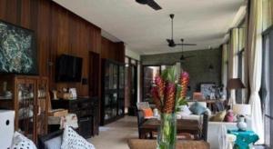 a living room with a couch and a vase with flowers at Villa De View in Ban Tham